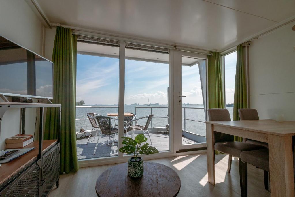 a living room with a view of the water at Blackbird in Biddinghuizen