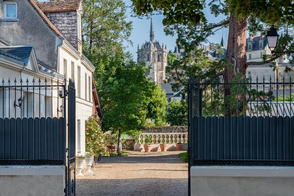 a gate to a house with a church in the background at Le Clos Richelieu in Amboise