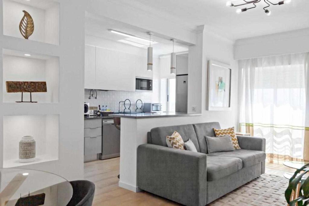 a living room with a couch and a kitchen at Timeless Sea I Apartment in Armação de Pêra