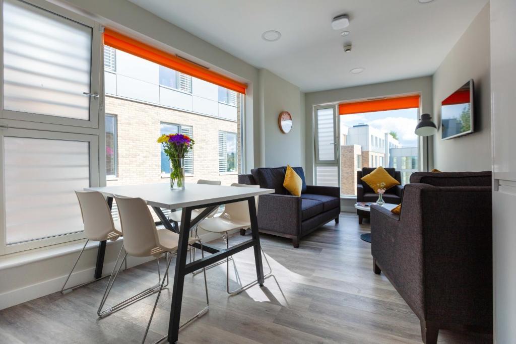 a living room with a table and chairs and a couch at The Westwood Apartments in Galway