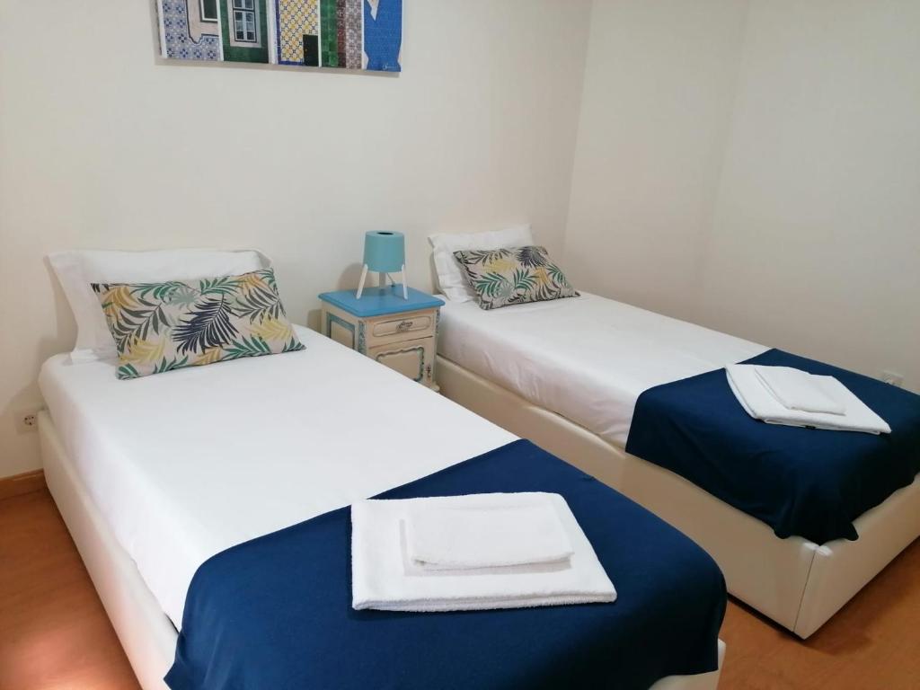 ヴィラ・ノヴァ・デ・ガイアにあるPortus Ribeira Houseのベッド2台、テーブル(ランプ付)が備わる客室です。