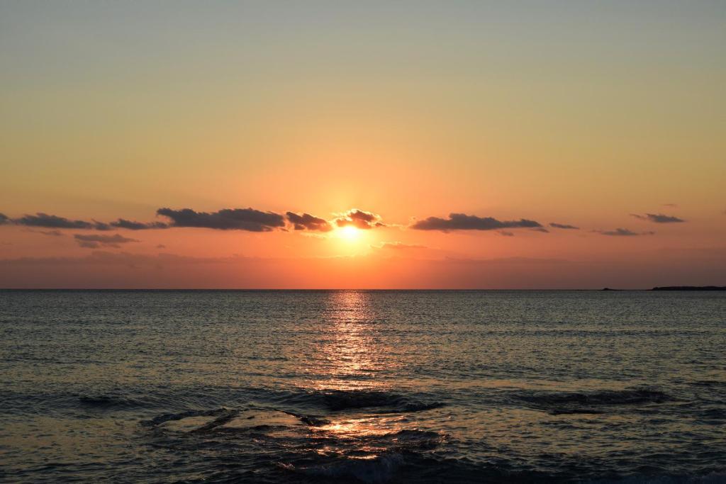 a sunset over the ocean with the sun setting at Hotel Plakures in Falasarna