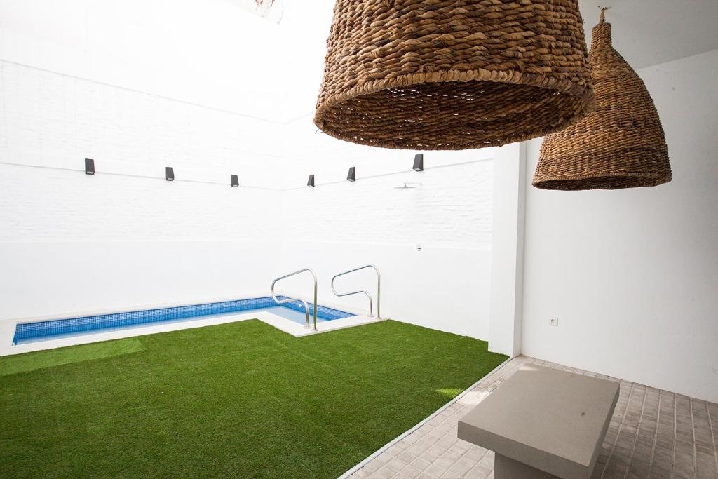 Azahar de Sevilla Apartments في إشبيلية: غرفة مع حمام سباحة مع عشب أخضر