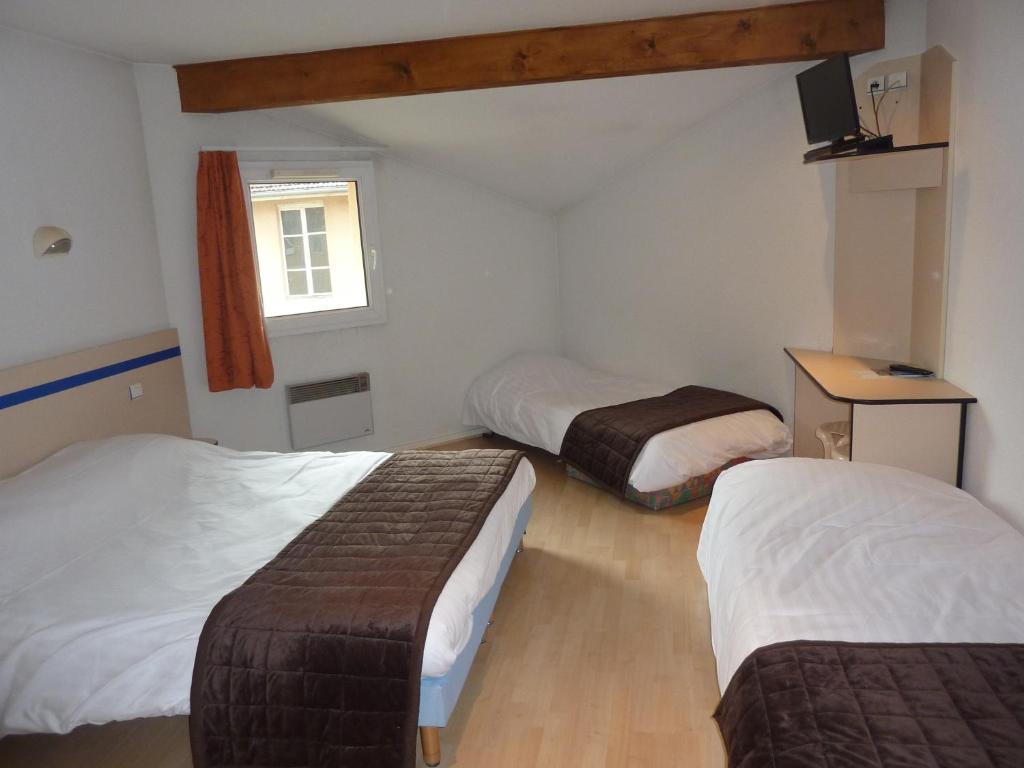 a hotel room with two beds and a window at Lac'Hotel France in Montréal La Cluse