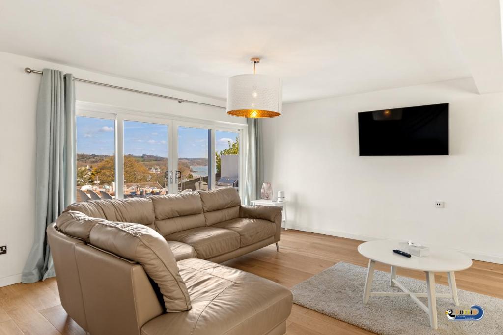 a living room with a couch and a table at Am Byth - Luxury Cottage, Sea Views in Saundersfoot