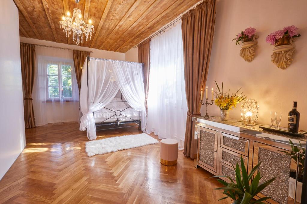 een woonkamer met houten vloeren en een kroonluchter bij Przystanek Szlakówka in Szczebrzeszyn