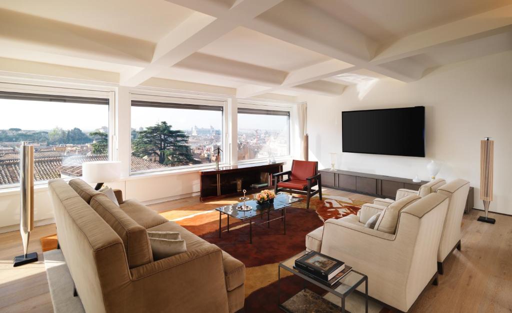 a living room with couches and a flat screen tv at Hotel Eden - Dorchester Collection in Rome