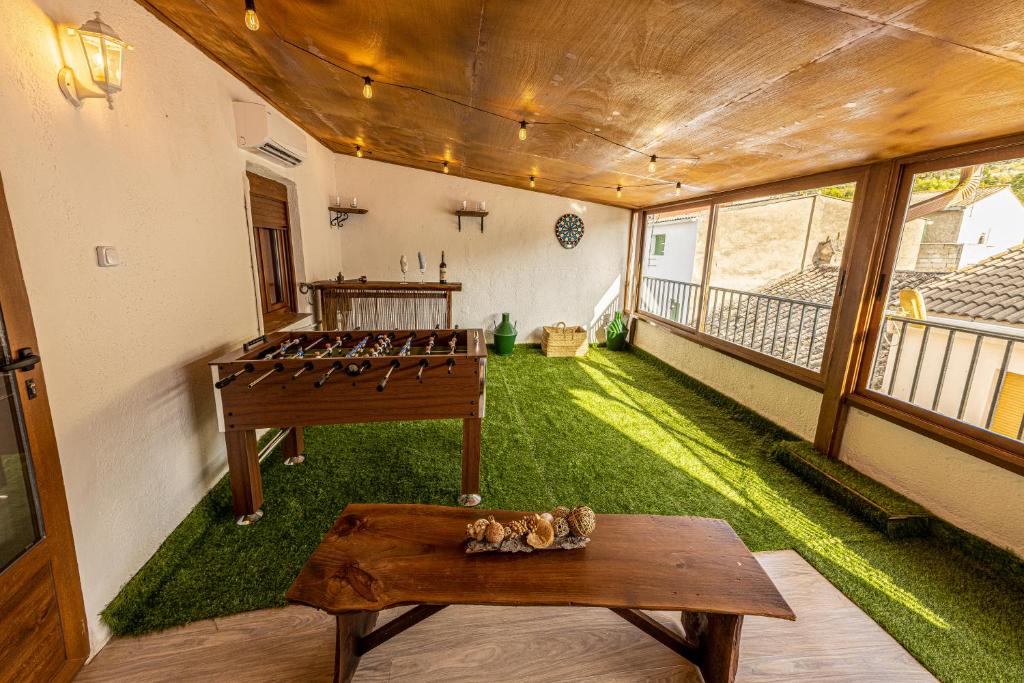 um quarto com um pátio verde com uma mesa em Casa El Forestal em Arbuniel