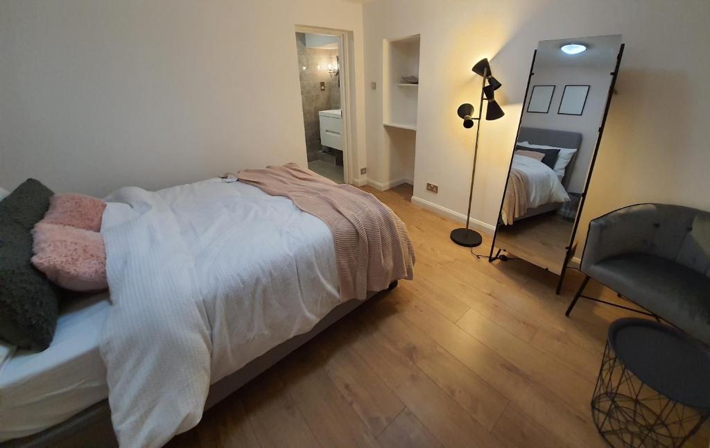 倫敦的住宿－Double Room in Central London，一间卧室配有一张床、镜子和椅子