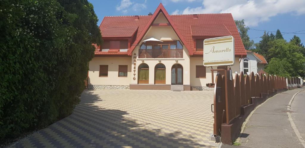 a large house with a fence in front of it at Amaretto Szállás in Miskolctapolca