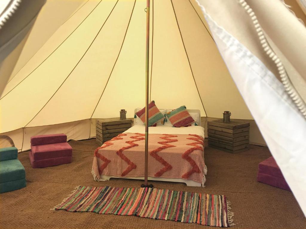 a bedroom with a bed in a tent at Glamp Natura Kryspinów in Cholerzyn