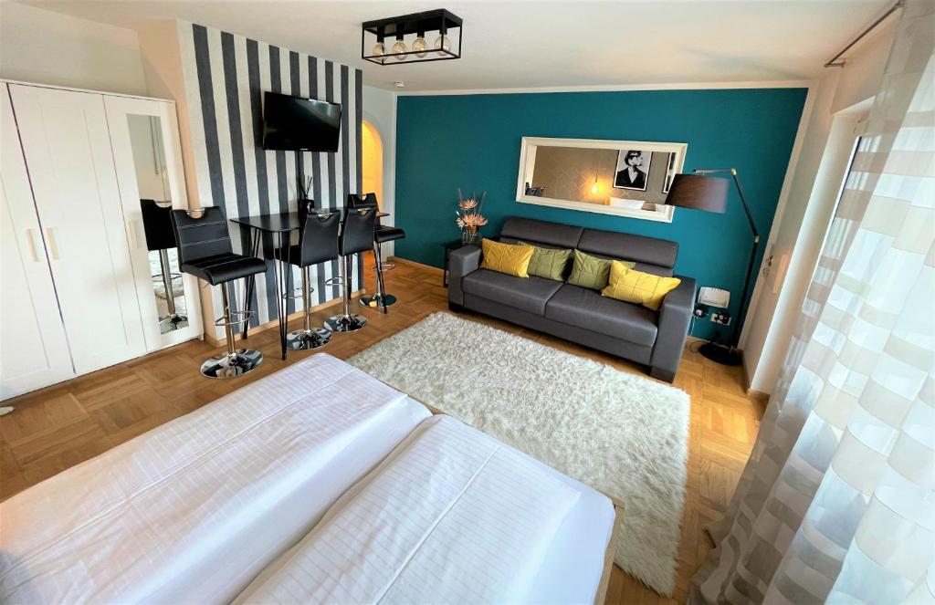 Design Apartment Vendome في فريبورغ ام بريسغاو: غرفة معيشة مع أريكة والجدار الأزرق