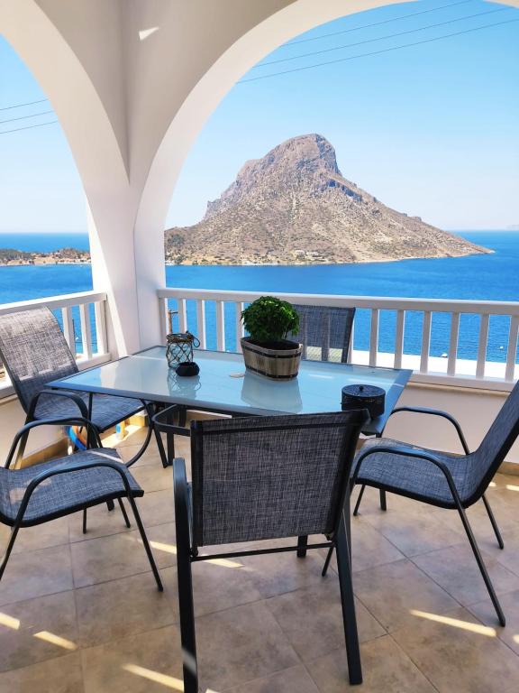 a table and chairs on a balcony with a view of the ocean at Via Ferrata Houses in Kalymnos