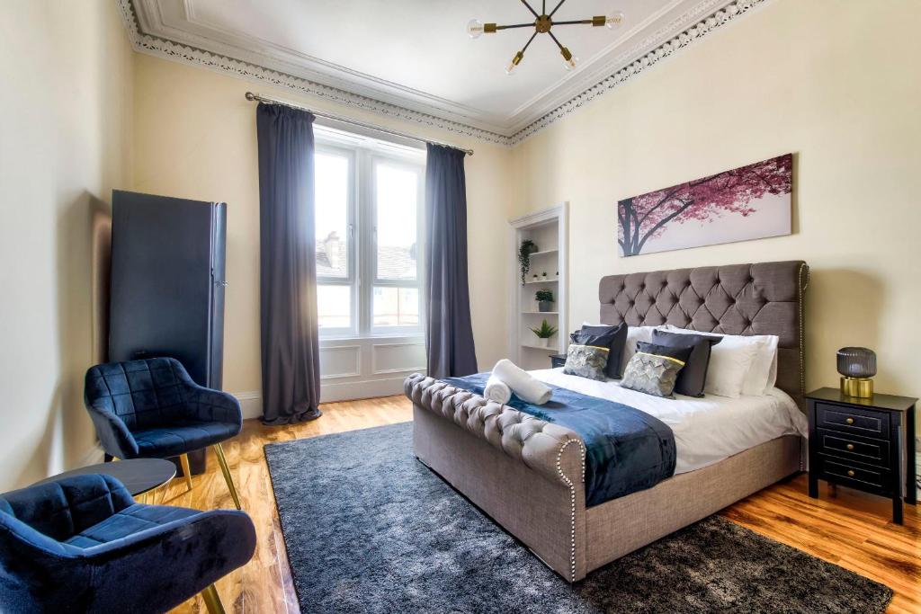 a bedroom with a bed and a chair and a window at Stunning 5 bedroom apt, close to city centre, SEC, Hydro and motorway in Glasgow