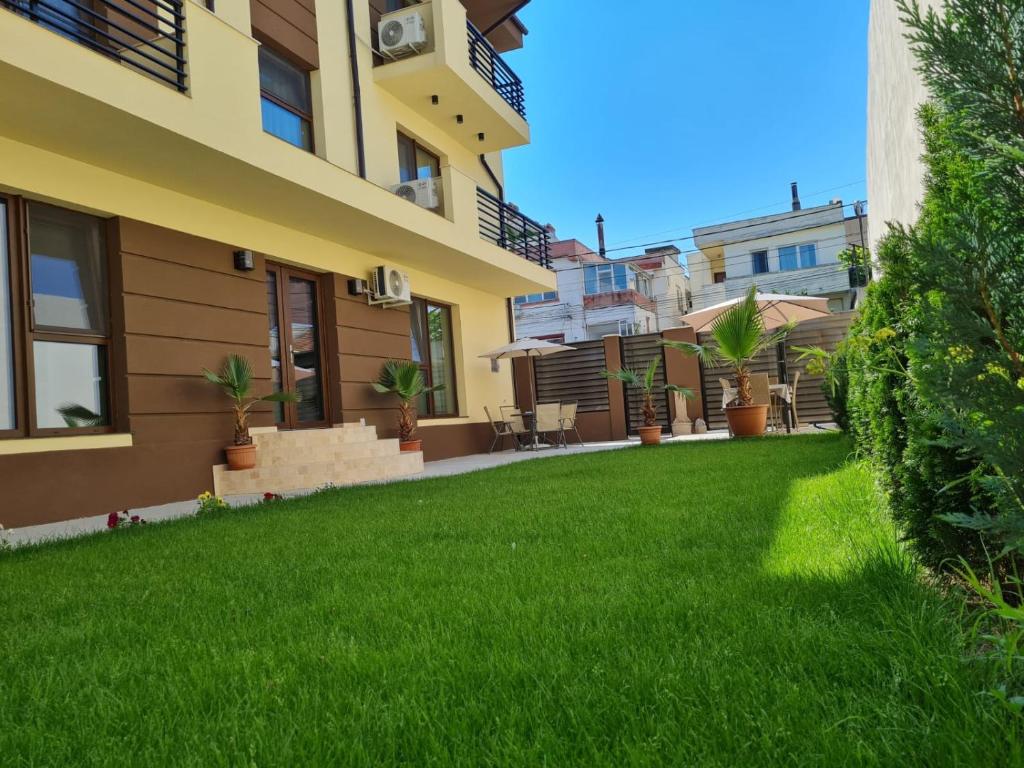 un patio de una casa con césped verde en VILA MRV en Constanza