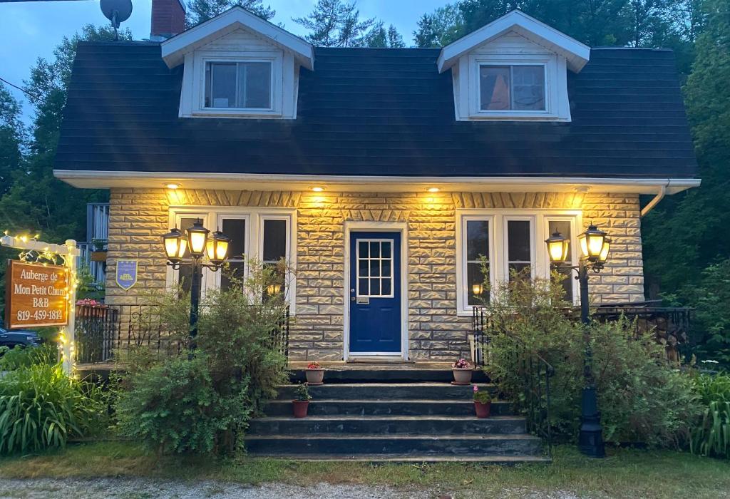 a small house with a blue door and lights at Auberge De Mon Petit Chum B&B in Wakefield