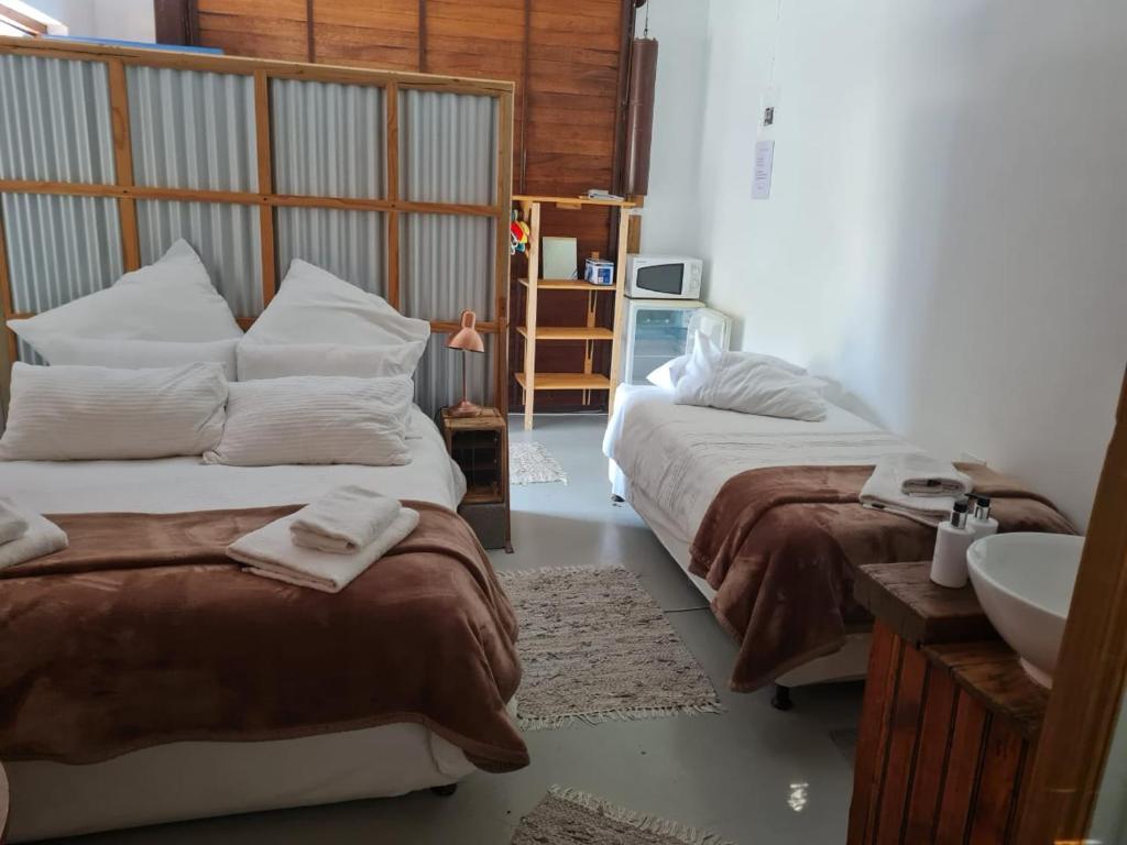 1 dormitorio con 2 camas y lavamanos. en DIE WAENHUIS, en Swellendam