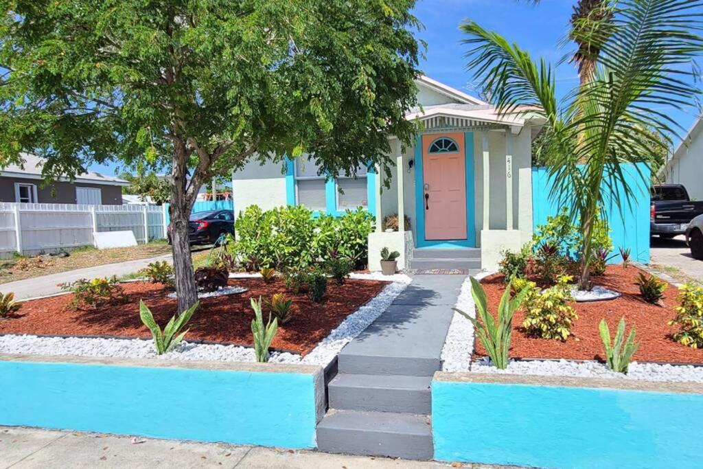 une maison bleue avec un arbre en face dans l'établissement Lake Worth Beach Paradise Cove Cottage 2-1Bedroom, à Lake Worth