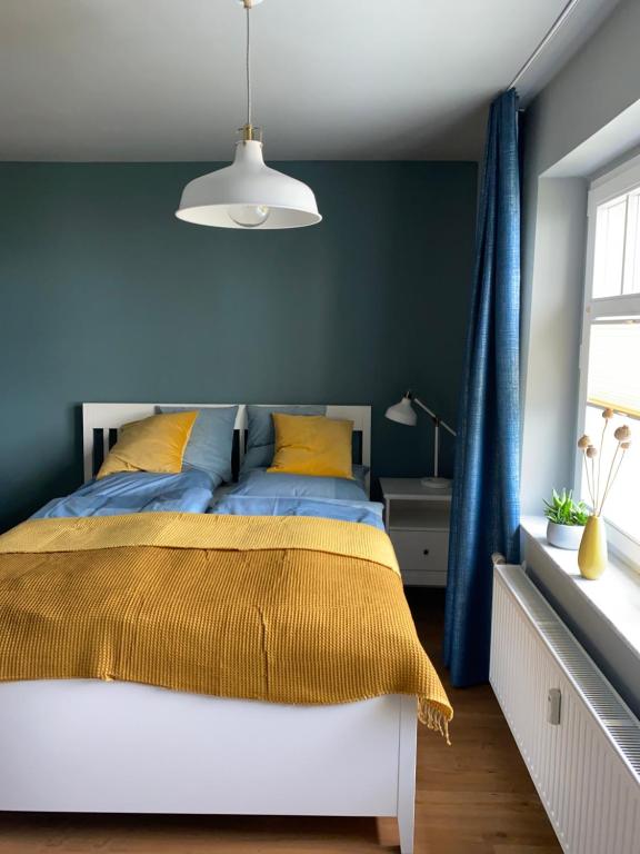 um quarto com uma cama com uma parede azul em Auszeit am Lindenpark em Kühlungsborn