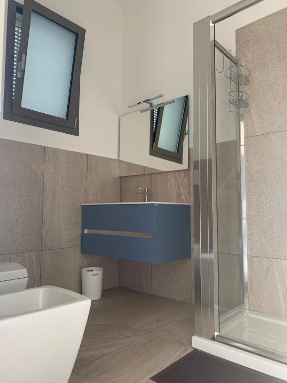 a bathroom with a blue sink and a shower at B&B CASA CALETA in Porto Cesareo