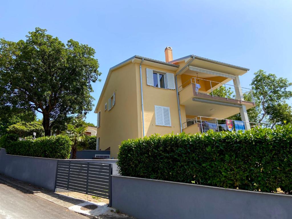 een geel huis met een hek ervoor bij Villa Rudy Holiday Home in Njivice