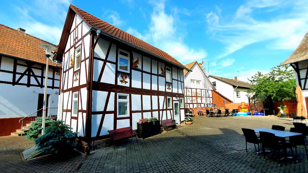 ein Gebäude mit einem Tisch und Stühlen im Innenhof in der Unterkunft Zur Krone - Ferienhaus 1 in Widdershausen