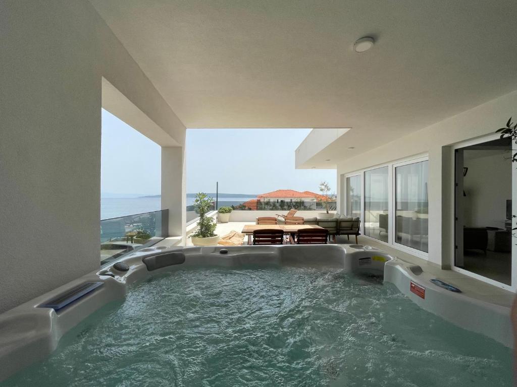 eine große Badewanne in einem Zimmer mit Meerblick in der Unterkunft Exclusive 2 Bedroom Seafront Suite with jacuzzi in Zavala
