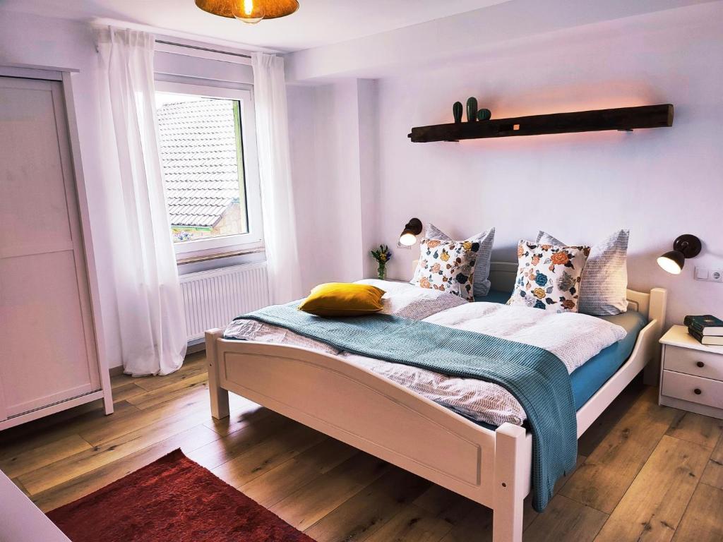 Webers Ferienwohnungen في Hilders: غرفة نوم بها سرير في غرفة بها نافذة