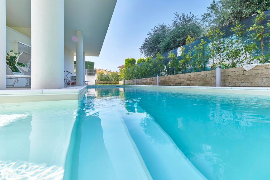 a swimming pool with blue water in a house at ApartmentsGarda - Le Terrazze Del Garda Residence in Lazise