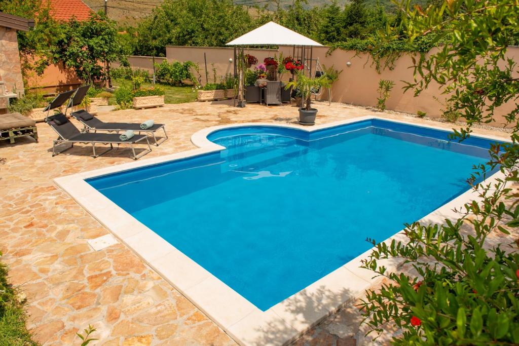 una piscina in un cortile con una sedia e un tavolo di Villa Bella a Mostar