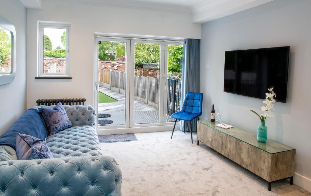 a living room with a couch and a flat screen tv at The Courtyard Lymm in Lymm