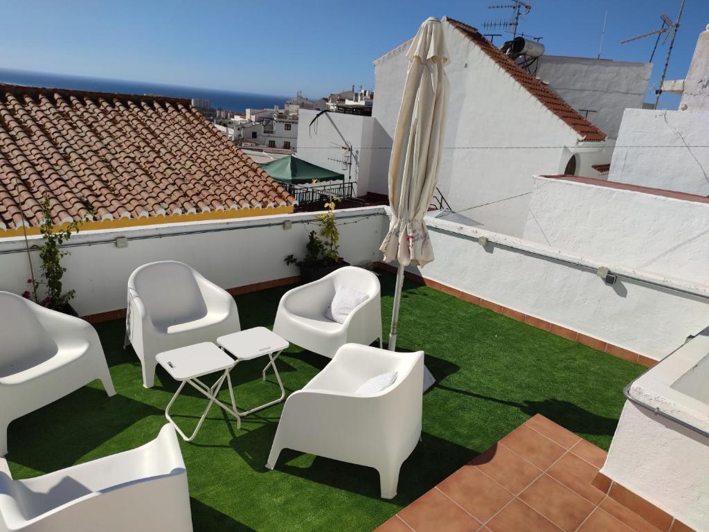 un patio avec des chaises et un parasol sur le toit dans l'établissement La Salamandra Azul, à Salobreña
