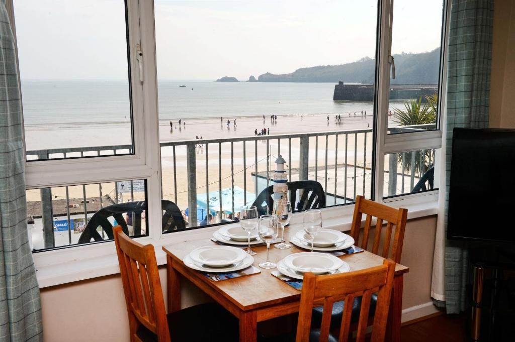 a dining table with a view of the beach at Mermaid Apartment - Sea Front Apartment with Views in Saundersfoot