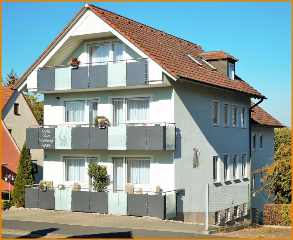 - un grand bâtiment avec des balcons sur le côté dans l'établissement Hotel-garni 'Zum Weinkrug', à Sommerhausen