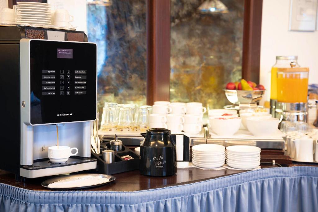 a counter with a coffee maker and cups and a coffee maker at Hotel Astoria am Urachplatz in Stuttgart