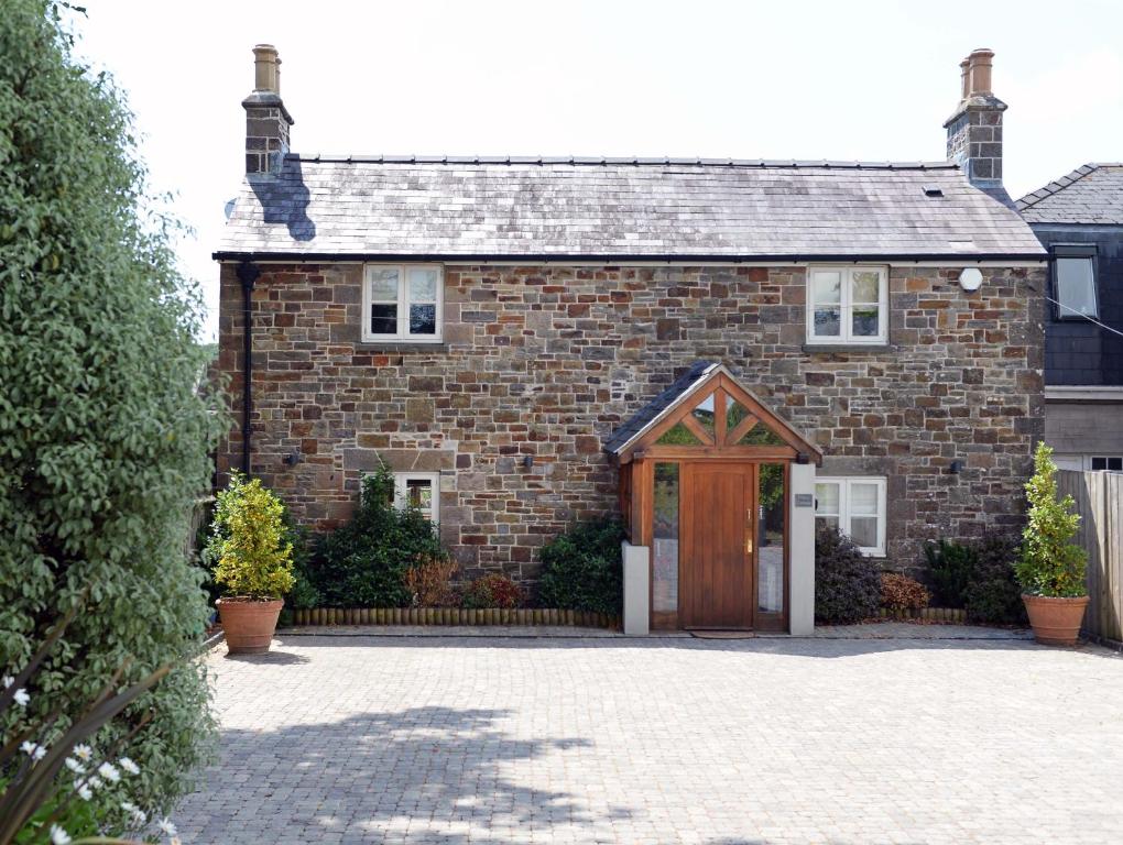 a brick house with a wooden door at Priory Cottage - Luxury Cottage, Near to Beach in Saundersfoot