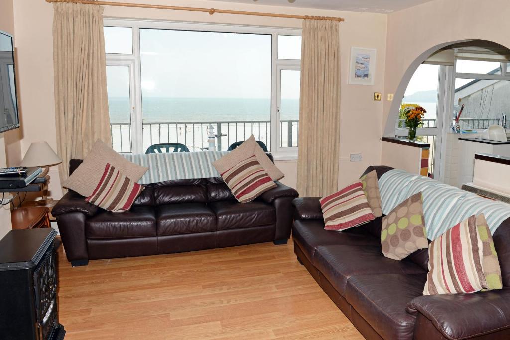 sala de estar con sofá de cuero y balcón en Sea View Apartment - Sea Front Apartment with Views en Saundersfoot