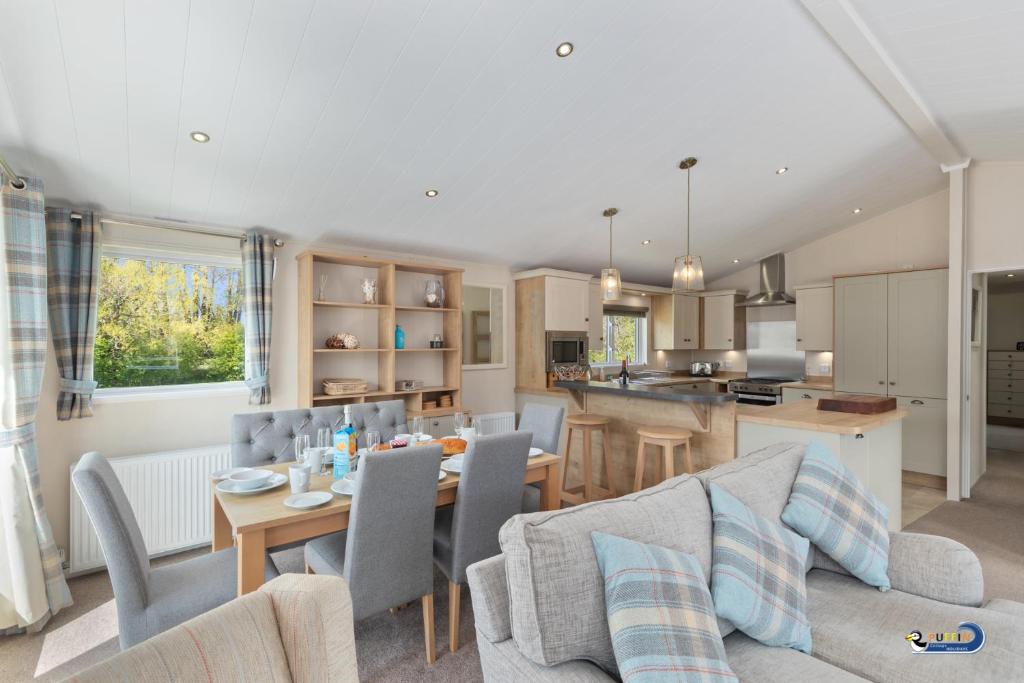 a kitchen and living room with a table and chairs at St Mary's View - Luxury Lodge, Short Walk to Beach, Parking in Tenby