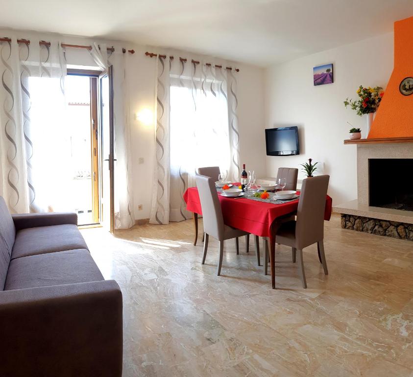 a living room with a red table and chairs at Casa Ahmati Borgo Vesio in Tremosine Sul Garda
