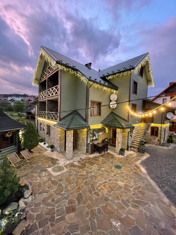 an exterior view of a house with a stone patio at Zatyshok nad Prutom in Bukovel