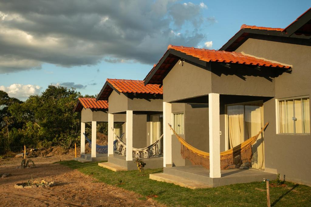 a row of houses with orange roofs in a yard at Chalés Magia Da Lua in Cavalcante