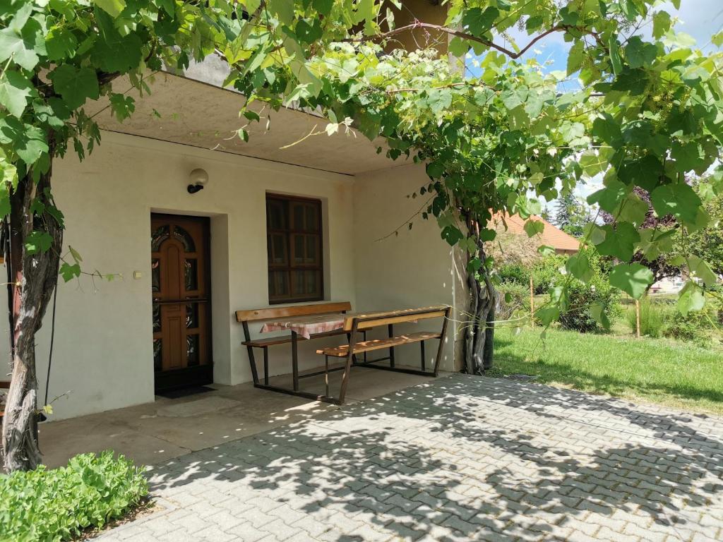 a bench in front of a house with a door at Éva Apartmanház 2 in Csopak