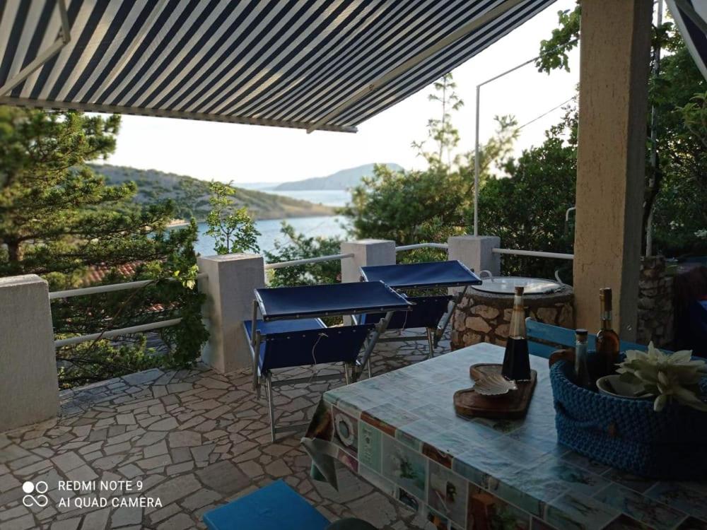 a patio with chairs and tables and a view of the water at Apartment Lili in Lukovo
