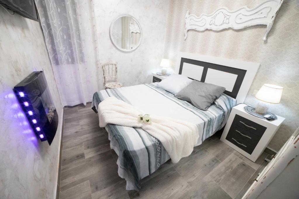 een slaapkamer met een bed en een flatscreen-tv bij APARTAMENTO LA VEGUILLA JUNIOR in Alhama de Aragón