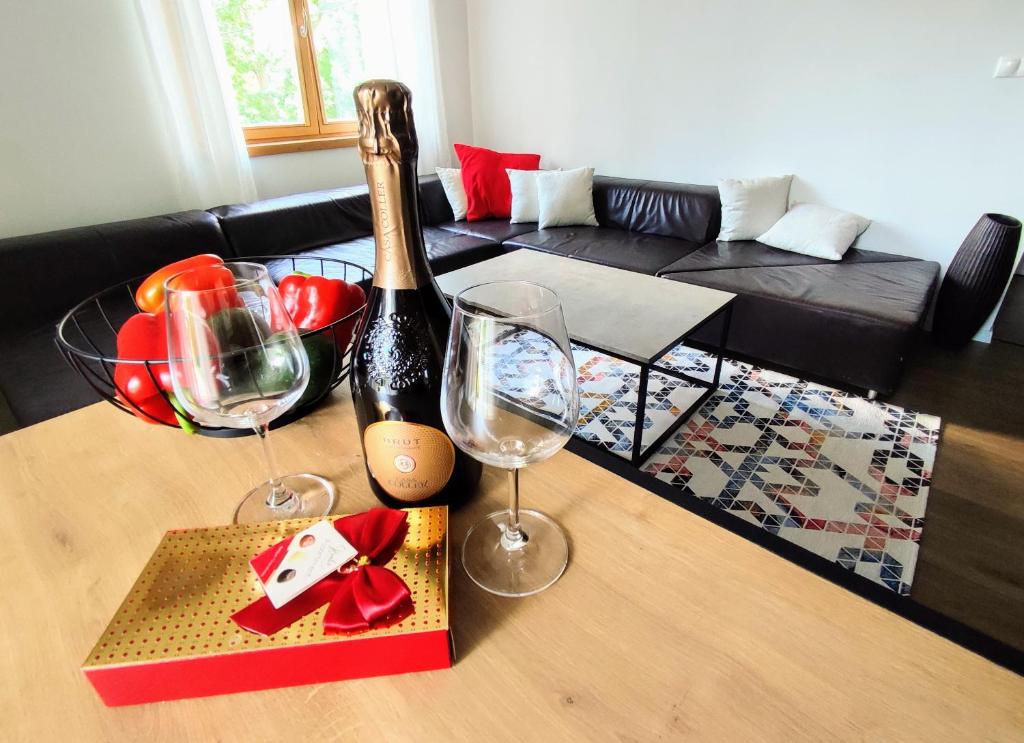 een woonkamer met twee wijnglazen op een tafel bij Apartman Panorama Park & Free Parking in Žilina