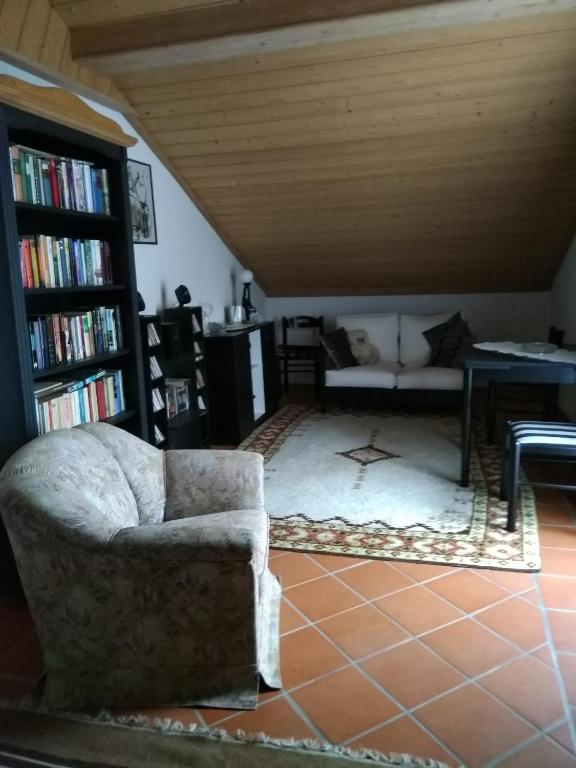 ein Wohnzimmer mit einem Stuhl und einem Bücherregal in der Unterkunft Ferienwohnung Haubner in Litschau