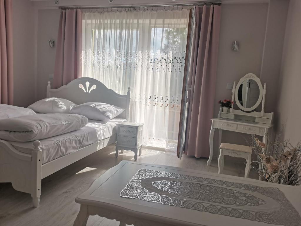 sypialnia z łóżkiem i oknem z lustrem w obiekcie APARTAMENT Magurka w mieście Rycerka Górna