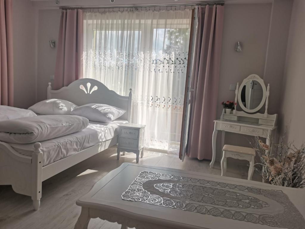a bedroom with a bed and a window with a mirror at APARTAMENT Magurka in Rycerka Górna