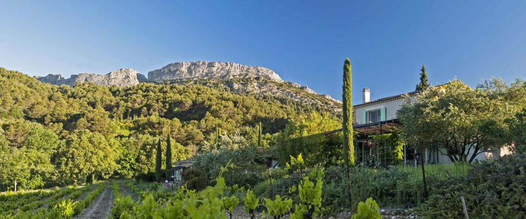 una casa en una colina con una montaña al fondo en Chambres & Table d'Hôtes Au Soleil du Bonheur, en Lafare