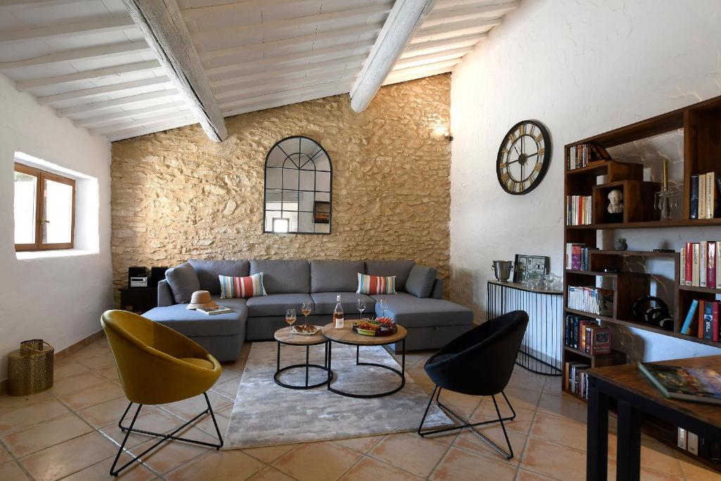 uma sala de estar com um sofá, cadeiras e uma mesa em Gîte des Demoiselles en Luberon em Roussillon